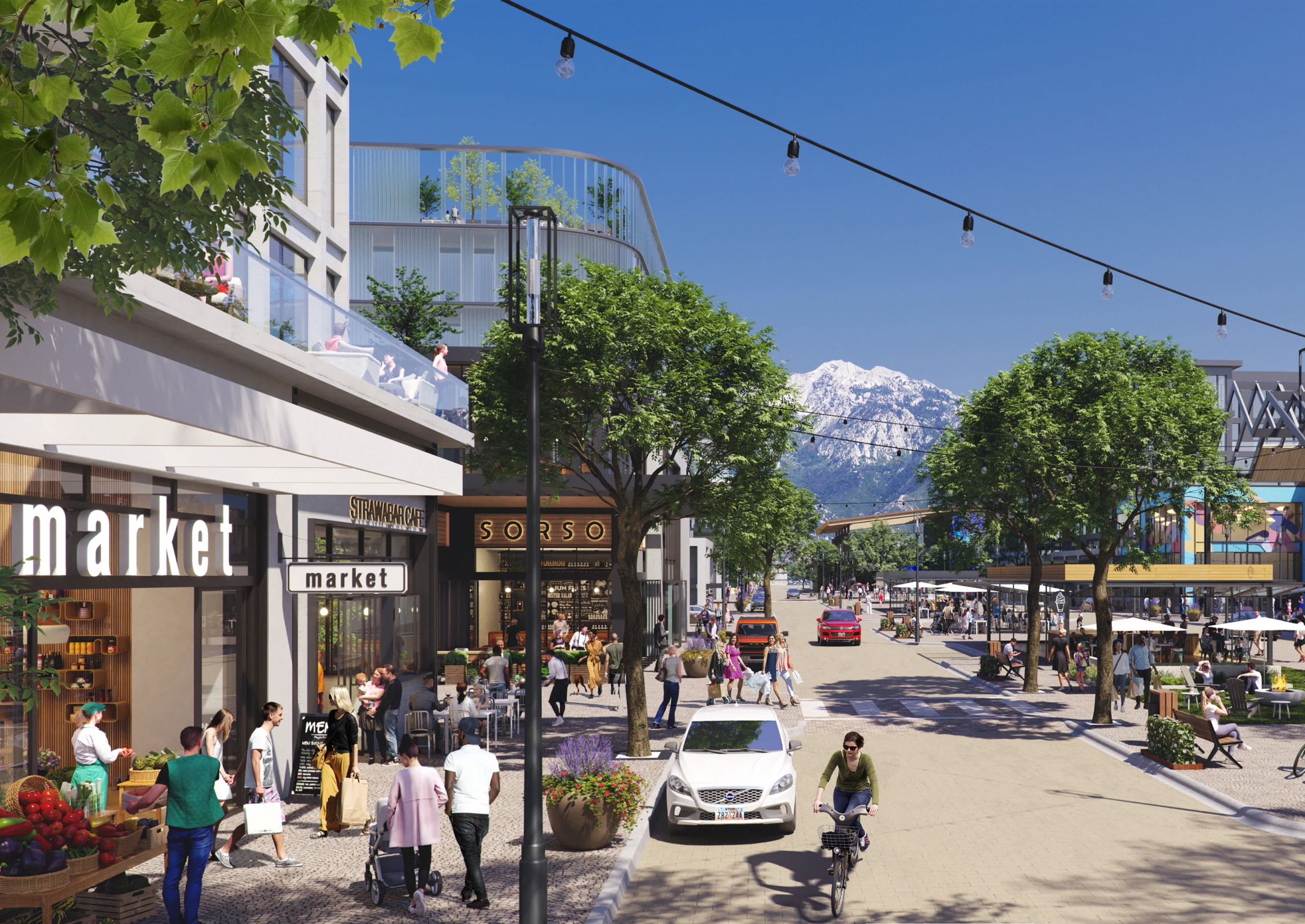 A lively pedestrian-friendly urban district set against a stunning mountain backdrop. The image showcases a bustling street lined with modern buildings featuring retail shops, cafes, and restaurants. People are walking, shopping, and dining outdoors, while others cycle or relax on benches under tree-lined sidewalks. Overhead string lights add charm to the atmosphere, and a sleek architectural design blends with the natural surroundings. In the distance, snow-capped mountains rise majestically, enhancing the sense of harmony between urban life and nature.